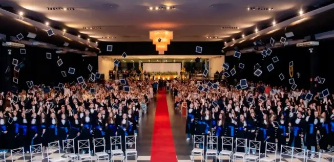 Formatura do Uni, com os formandos jogando os capelos